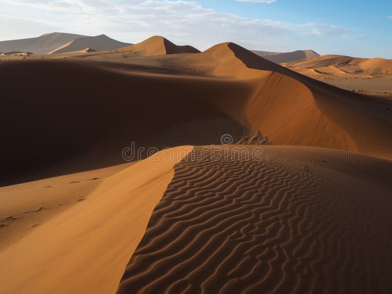 A linha e o vento curvados naturais bonitos do cume fundem o teste padrão da duna de areia vermelha oxidada com máscara e da somb imagens de stock A linha e o vento curvados naturais bonitos do cume fundem o teste padrão da duna de areia vermelha oxidada com máscara e da somb imagens de stock