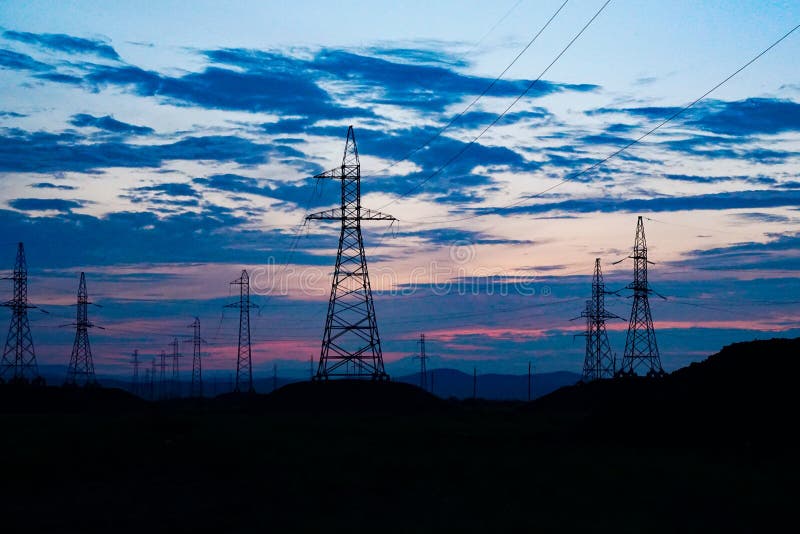 Linie energetyczne przeciw ciemnemu zmierzchu niebu obraz stock Linie energetyczne przeciw ciemnemu zmierzchu niebu obraz stock