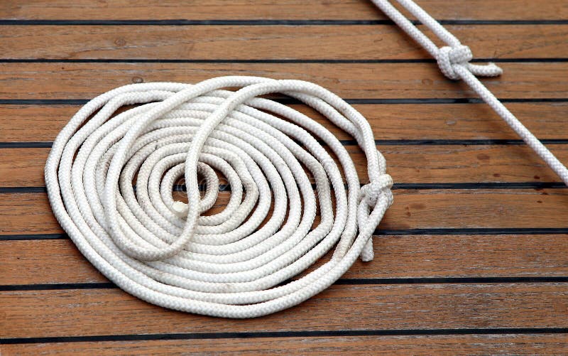 Sailing rope rolled up lying on wooden deck of yacht. Sailing rope rolled up lying on wooden deck of yacht.