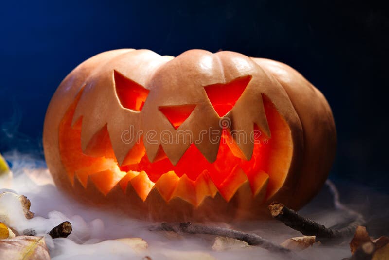 Linterna de la calabaza de Halloween con las hojas secas con las velas ardientes foto de archivo libre de regalías Linterna de la calabaza de Halloween con las hojas secas con las velas ardientes foto de archivo libre de regalías