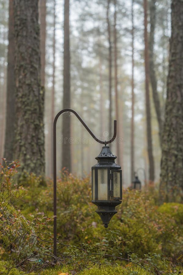 Black grave lantern in a misty forest, close up. Black grave lantern in a misty forest, close up