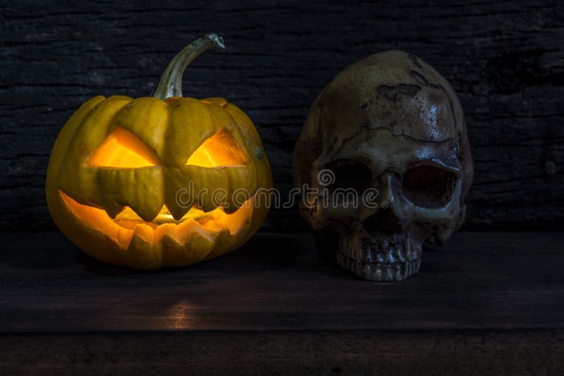 Linterna del enchufe de la cabeza de la calabaza de Halloween con el cráneo humano imagen de archivo Linterna del enchufe de la cabeza de la calabaza de Halloween con el cráneo humano imagen de archivo
