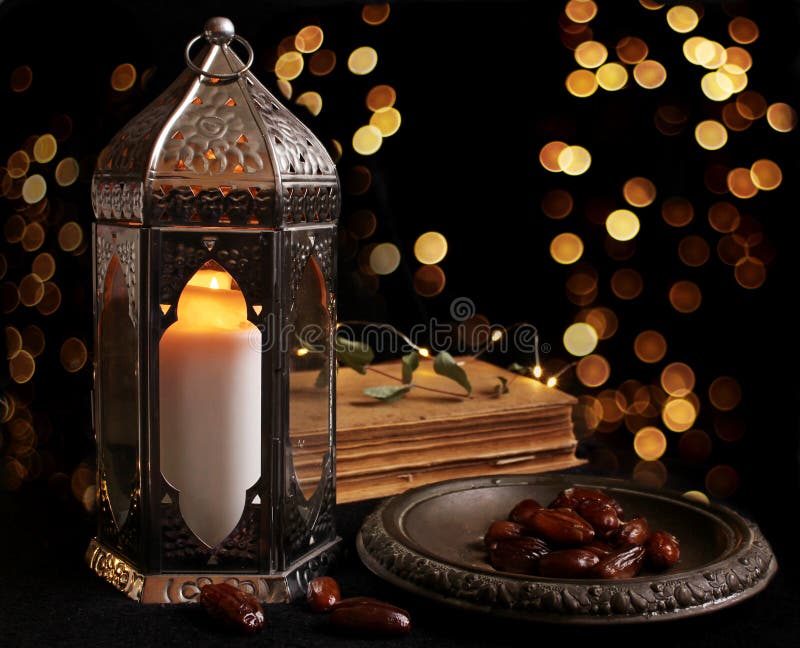 Linterna árabe ornamental con la vela ardiente que brilla intensamente en la noche y las luces de oro del bokeh que brillan Tarje foto de archivo libre de regalías Linterna árabe ornamental con la vela ardiente que brilla intensamente en la noche y las luces de oro del bokeh que brillan Tarje foto de archivo libre de regalías