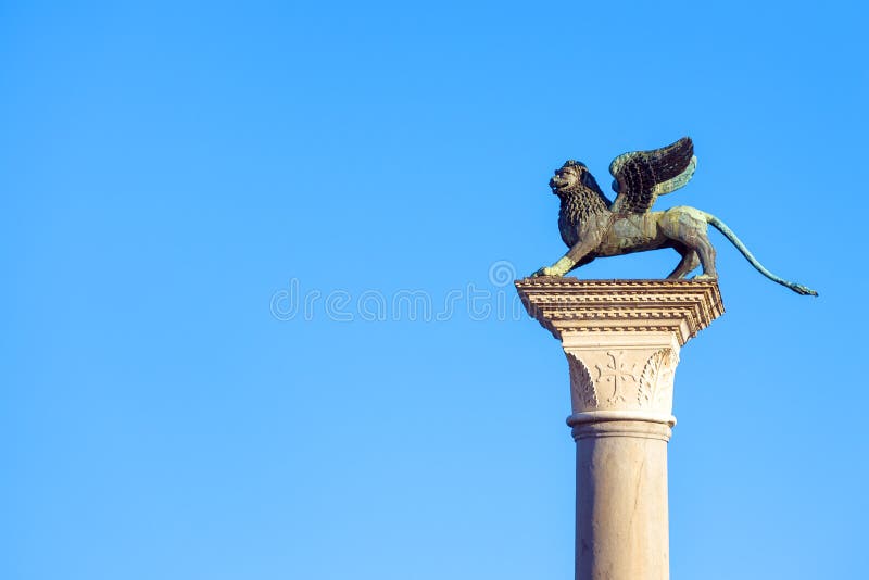 Lion statue at Piazza San Marco St Mark`s Square on blue sky background, Venice, Italy. This place is a tourist attraction of