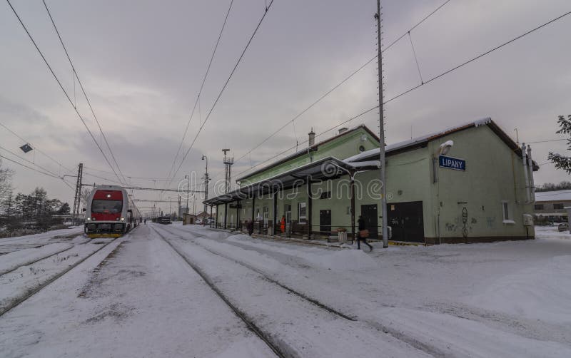 Nádraží Lipany v zimním sněhovém ránu s vlaky a nástupišti