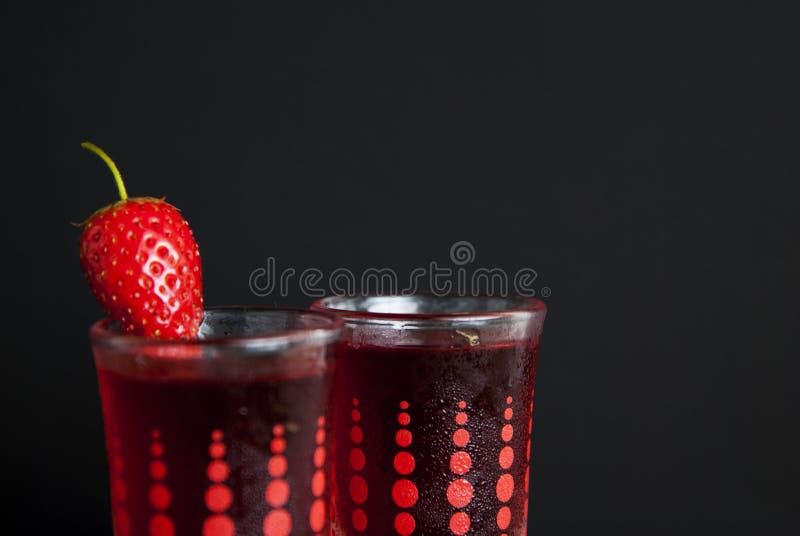 Liqueur rouge de baies dans le verre à liqueur d'isolement sur le fond noir et la table en bois Concept fait maison de boissons d photos stock Liqueur rouge de baies dans le verre à liqueur d'isolement sur le fond noir et la table en bois Concept fait maison de boissons d photos stock