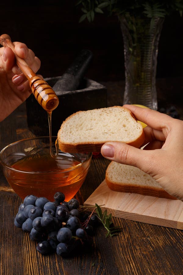 The Liquid Honey Flows from the Honey Stick on a Slice of Bread Stock