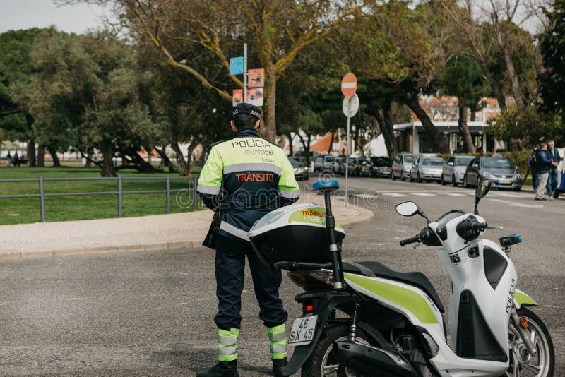 Lisboa, o 18 de junho de 2018: O polícia da patrulha ao lado da motocicleta guarda a ordem pública Um representante da lei e foto de stock royalty free Lisboa, o 18 de junho de 2018: O polícia da patrulha ao lado da motocicleta guarda a ordem pública Um representante da lei e foto de stock royalty free