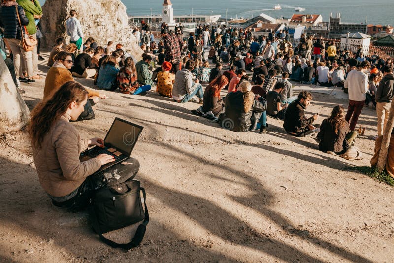 Lisboa, o 1º de maio de 2018: Um estudante da moça ou um blogger ou um freelancer trabalham no computador ou comunicam-se no Inte imagem de stock Lisboa, o 1º de maio de 2018: Um estudante da moça ou um blogger ou um freelancer trabalham no computador ou comunicam-se no Inte imagem de stock
