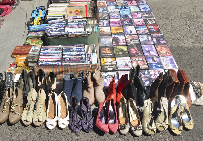 Lisboa, Portugal - 5 de agosto de 2017: Colección de la película del DVD y montón de zapatos usados viejos de mujeres en el merca fotografía de archivo Lisboa, Portugal - 5 de agosto de 2017: Colección de la película del DVD y montón de zapatos usados viejos de mujeres en el merca fotografía de archivo