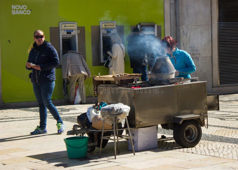 Lisbon, Portugalia: domokrążca kobiety sprzedawanie piec chestnusts w Rua Augusta (ulica) zdjęcia stock Lisbon, Portugalia: domokrążca kobiety sprzedawanie piec chestnusts w Rua Augusta (ulica) zdjęcia stock