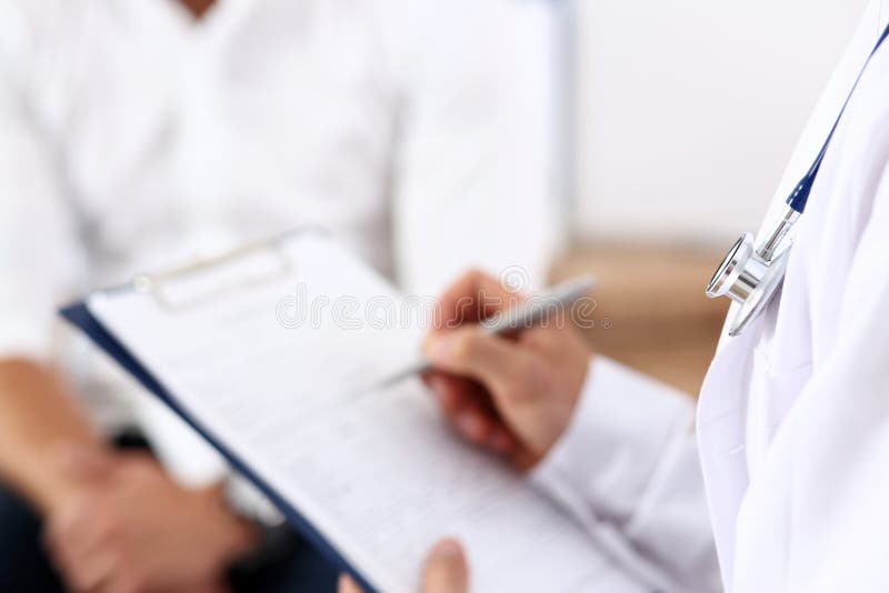 Lista di riempimento di storia del paziente di medico della mano della tenuta della penna maschio dell'argento fotografie stock Lista di riempimento di storia del paziente di medico della mano della tenuta della penna maschio dell'argento fotografie stock