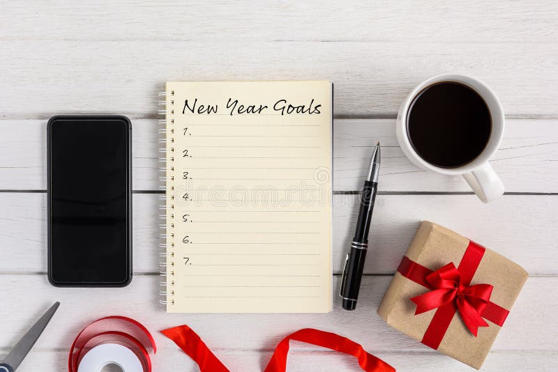 Lista noworocznych celów: notebook z pudełkiem na prezent i smartfonem, długopis, kawa zdjęcia stock Lista noworocznych celów: notebook z pudełkiem na prezent i smartfonem, długopis, kawa zdjęcia stock