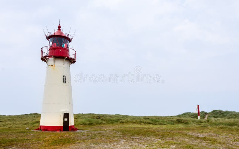 Lista-oeste do farol dentro de uma paisagem da duna com grama e areia Vista panorâmica em um dia claro Localizado em auf Sylt da foto de stock royalty free Lista-oeste do farol dentro de uma paisagem da duna com grama e areia Vista panorâmica em um dia claro Localizado em auf Sylt da foto de stock royalty free
