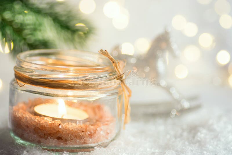 Lit candle in crystal jar candleholder hanging Christmas tree branch in snow ornament rocking horse in winter forest. New Year royalty free stock photos Lit candle in crystal jar candleholder hanging Christmas tree branch in snow ornament rocking horse in winter forest. New Year royalty free stock photos
