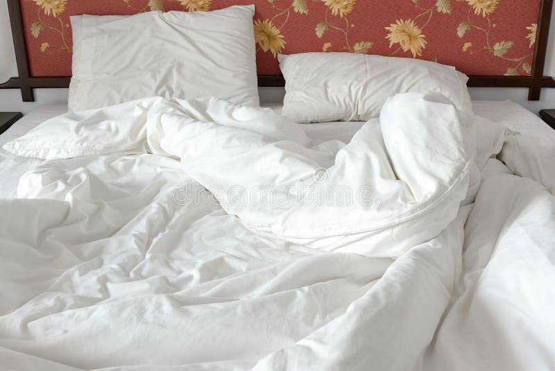 Lit qui n'est pas encore fait/désordonné avec un blanc a chiffonné la couverture et deux oreillers malpropres dans une salle de l photos libres de droits Lit qui n'est pas encore fait/désordonné avec un blanc a chiffonné la couverture et deux oreillers malpropres dans une salle de l photos libres de droits