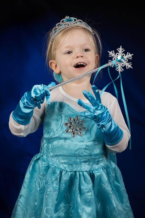 Lite blond lycklig flicka som kläs som den Disney fryste prinsessan Elsa arkivbild Lite blond lycklig flicka som kläs som den Disney fryste prinsessan Elsa arkivbild