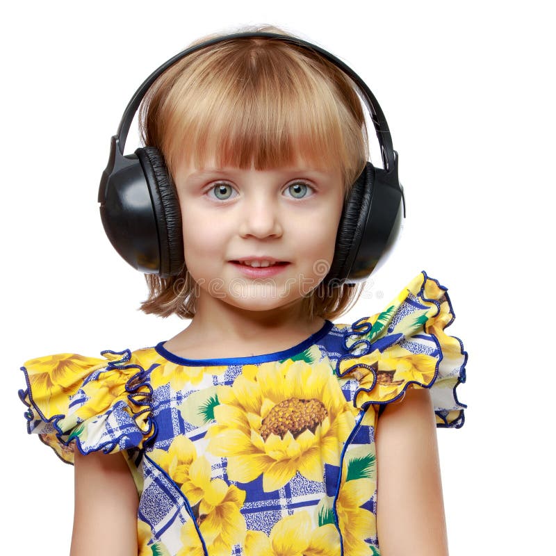Lite flicka med h?rlurar som lyssnar till musik arkivfoto Lite flicka med h?rlurar som lyssnar till musik arkivfoto
