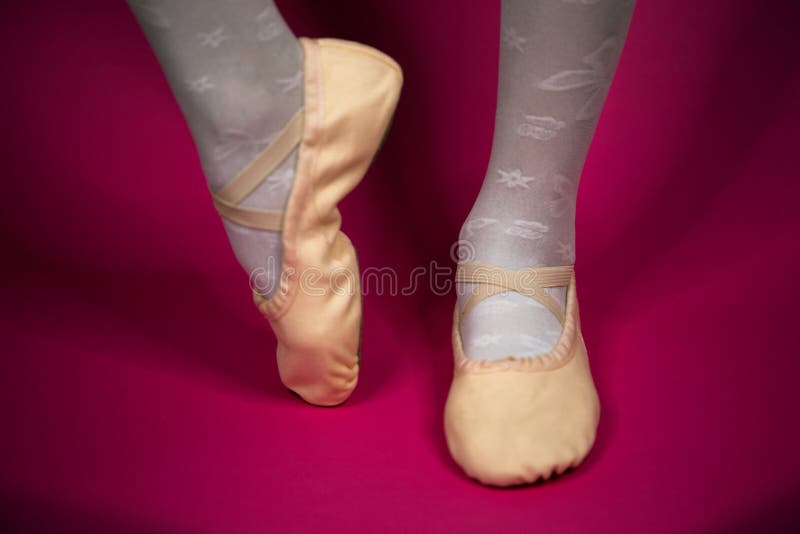 Liten ballerina ben i pointe p? en rosa bakgrund Balettposition