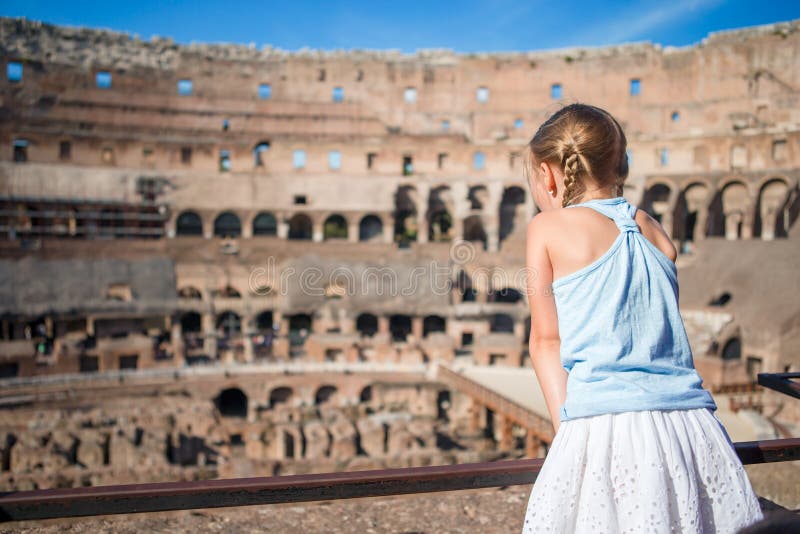 Liten flicka i coliseumen, Rome, Italien Tillbaka sikt av ungen som ser berömda ställen i Europa arkivbild Liten flicka i coliseumen, Rome, Italien Tillbaka sikt av ungen som ser berömda ställen i Europa arkivbild