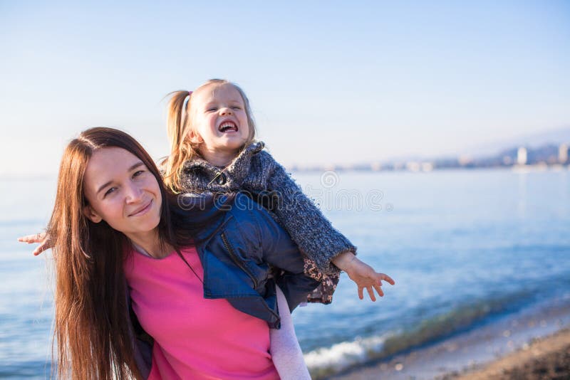 Liten flicka med mamman som har gyckel på stranden i a royaltyfria foton Liten flicka med mamman som har gyckel på stranden i a royaltyfria foton
