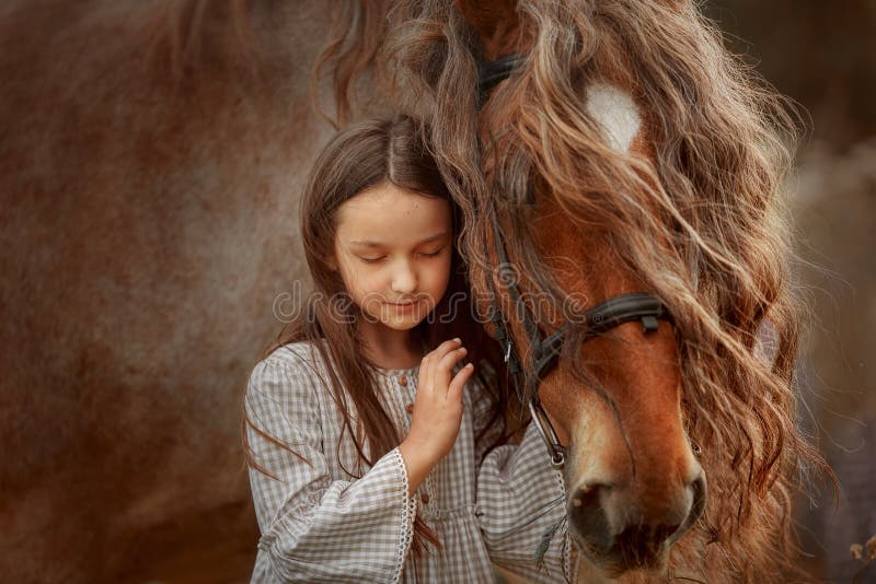 Long haired Little girl  in casual style with palomino miniature horse stallion in summer day. Long haired Little girl  in casual style with palomino miniature horse stallion in summer day