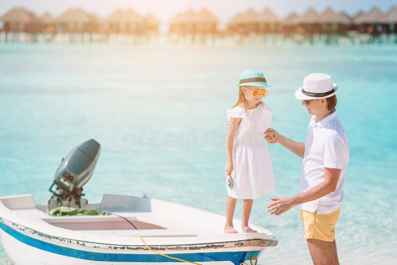 Liten flicka och lycklig pappa som hade kul på strandsemester arkivbilder