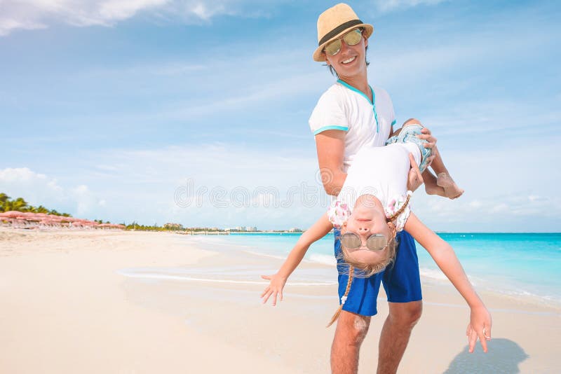 Liten flicka och lycklig pappa som hade kul på strandsemester arkivbilder