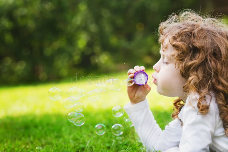Liten flicka som blåser såpbubblor, härlig byracka för closeupstående royaltyfri bild Liten flicka som blåser såpbubblor, härlig byracka för closeupstående royaltyfri bild