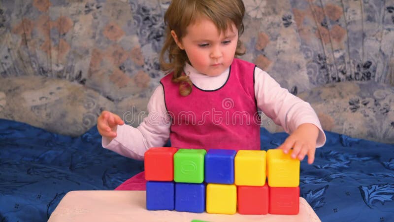 Liten flicka som spelar kuber på lager videofilmer