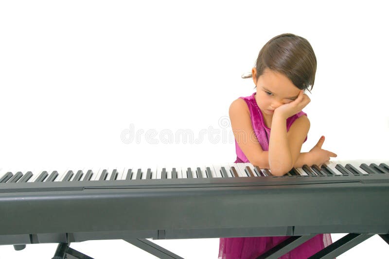 Liten flicka som tröttas, medan öva pianot