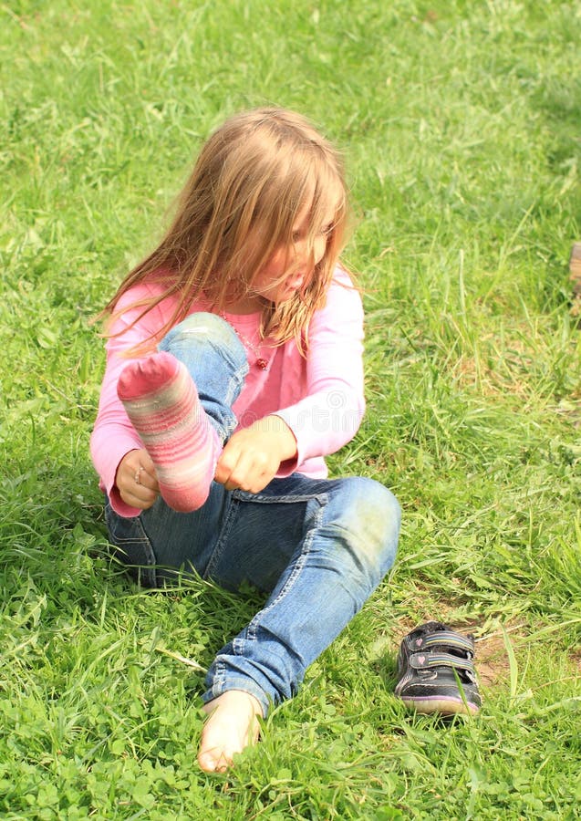 Liten flicka som upp klär sockor royaltyfria bilder Liten flicka som upp klär sockor royaltyfria bilder
