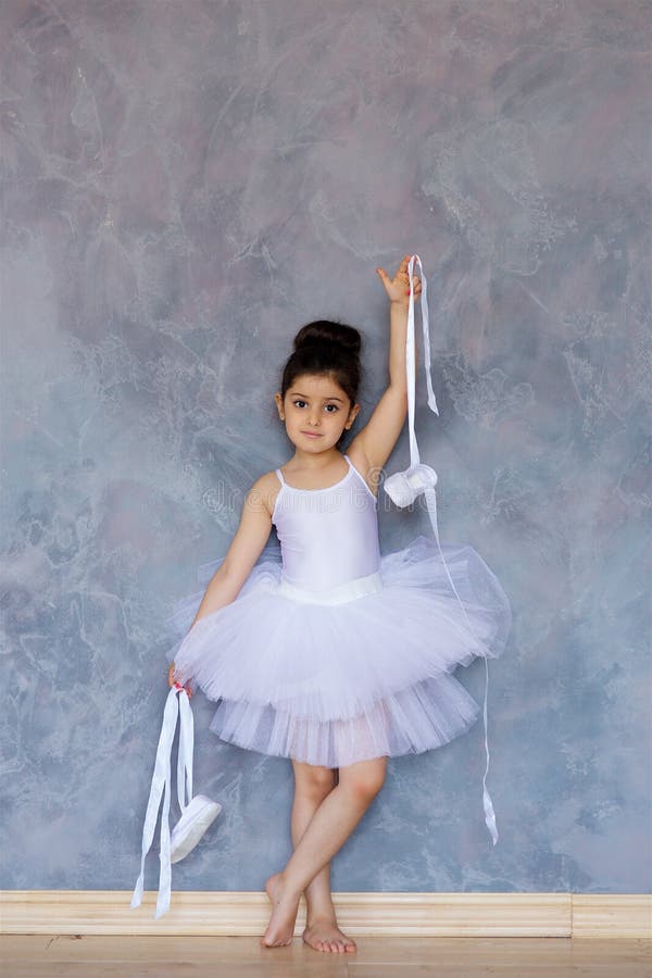 Liten flickaballerina i en vit ballerinakjol arkivbild Liten flickaballerina i en vit ballerinakjol arkivbild