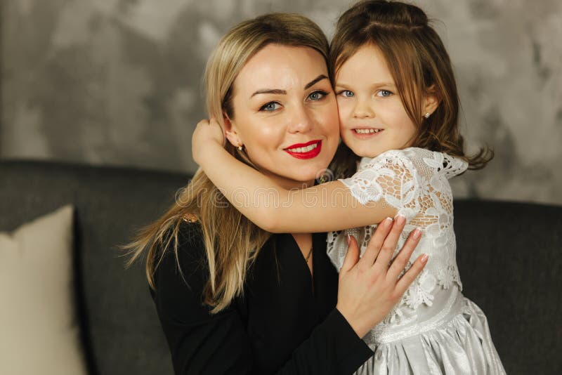 Liten flickakrammoder och leende Lycklig ung mamma med hennes dotter hemma arkivfoton Liten flickakrammoder och leende Lycklig ung mamma med hennes dotter hemma arkivfoton
