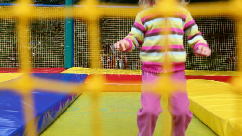 Liten glad flicka som hoppar på uppblåsbar trampolin arkivfilmer