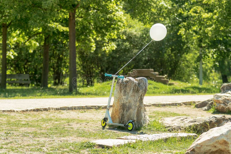 Liten hopfällbar sparkcykel i parkera arkivbilder Liten hopfällbar sparkcykel i parkera arkivbilder