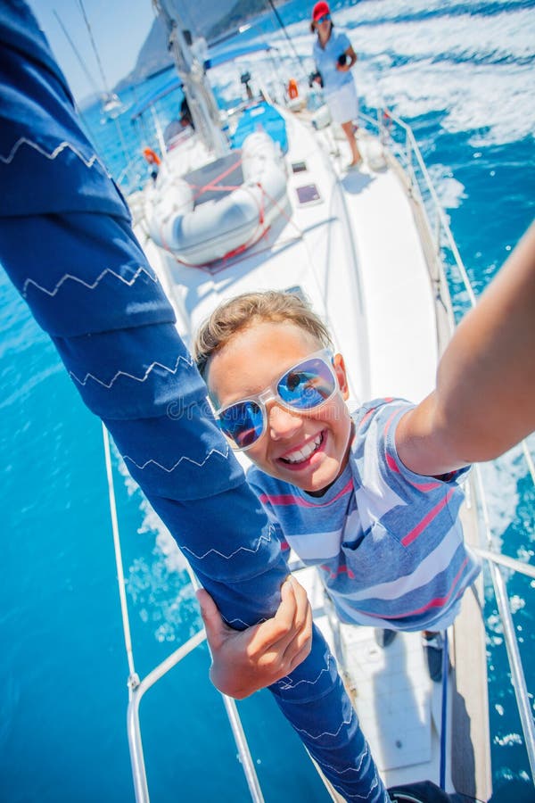 Liten pojke ombord på segeljakt på sommarkryssning. Yachning av resäventyr med barn på semester i familjen. arkivfoton
