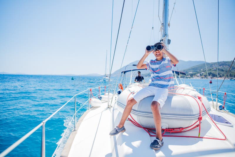 Liten pojke ombord på segeljakt på sommarkryssning. Yachning av resäventyr med barn på semester i familjen. fotografering för bildbyråer