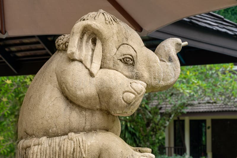 Liten rolig elefant, skulptur som sitter under ett paraply royaltyfria bilder Liten rolig elefant, skulptur som sitter under ett paraply royaltyfria bilder
