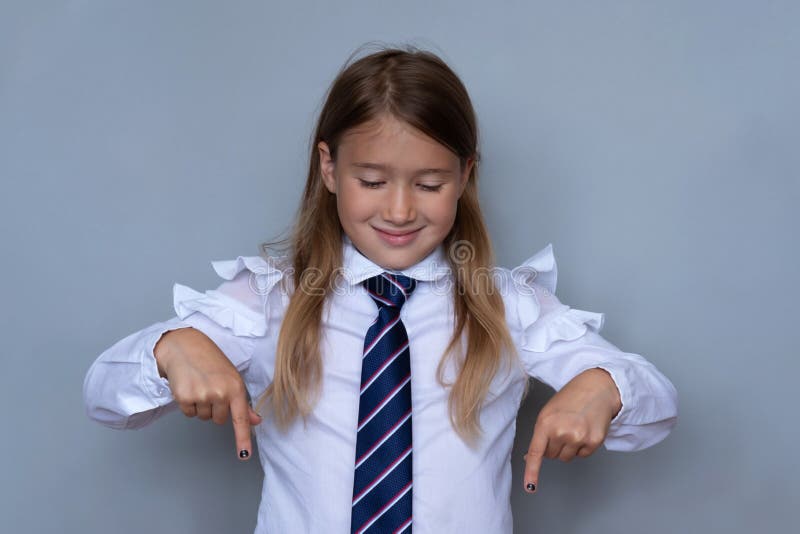 Liten skolflicka som pekar ner ståenden royaltyfri fotografi Liten skolflicka som pekar ner ståenden royaltyfri fotografi