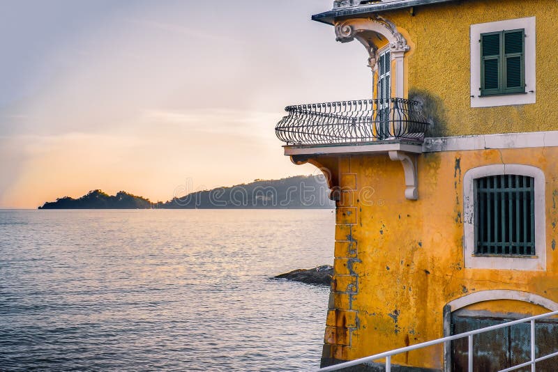 Liten terrass som in förbiser havet på solnedgången i den lyxiga forntida villan på golfen av Tigullio nära Portofino royaltyfria foton Liten terrass som in förbiser havet på solnedgången i den lyxiga forntida villan på golfen av Tigullio nära Portofino royaltyfria foton