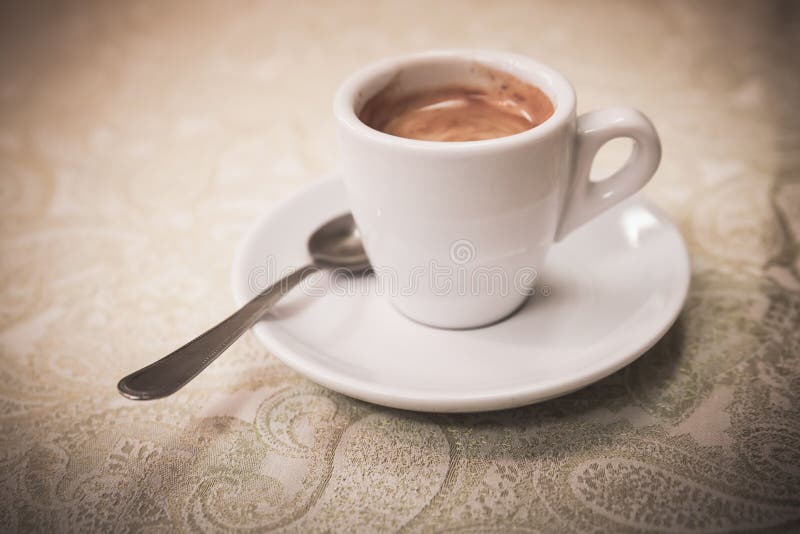 Liten vit kopp av espressokaffe, tappning arkivfoto