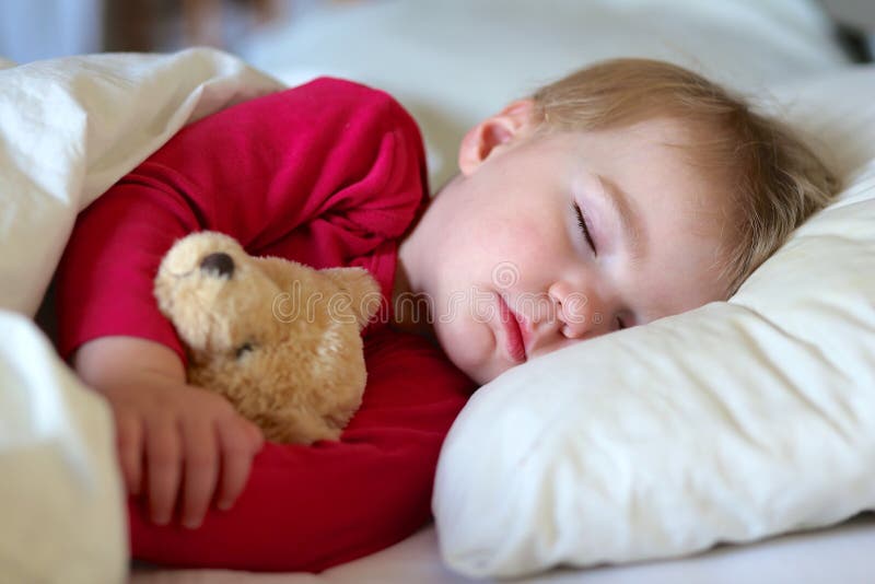 Litet barn som sover i säng arkivfoto Litet barn som sover i säng arkivfoto
