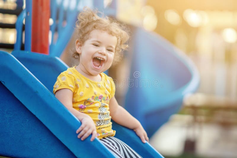 Litet litet barn som spelar på lekplatsdet fria i sommar arkivbild Litet litet barn som spelar på lekplatsdet fria i sommar arkivbild