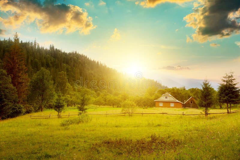 Litet hus på lutningen Carpathians på solnedgången arkivbild Litet hus på lutningen Carpathians på solnedgången arkivbild