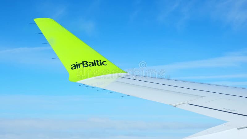 Lithuanie 18 juin 2023 aile d'avion parmi les nuages par jour ensoleillé. compagnie de logo airbaltic. banque de vidéos
