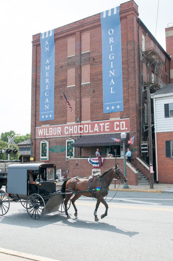 LITITZ, PA - SIERPIEŃ 30: Amish powozika i konia jazdy past lokuje na trasie 501 słynny Wilbur Czekolada Firma obraz royalty free LITITZ, PA - SIERPIEŃ 30: Amish powozika i konia jazdy past lokuje na trasie 501 słynny Wilbur Czekolada Firma obraz royalty free