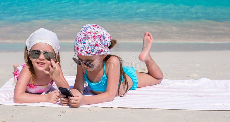 Little adorable girls playing in phone during