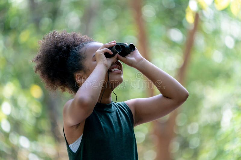 Little African American Girl with Binoculars during Hiking in Forest