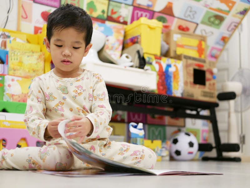 Little Asian baby opening and exploring a book